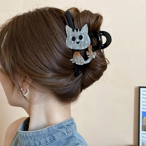 Vue détaillée d'une pince à cheveux chat en acétate sur un chignon de femme