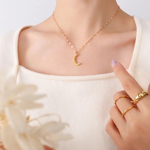 Elegance of 18K gold plated hammered moon pendant necklace with matching rings on model