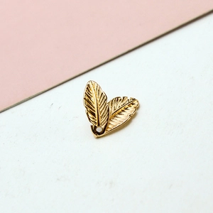 Detailed view of dual layered golden feather pendants with intricate metal textures