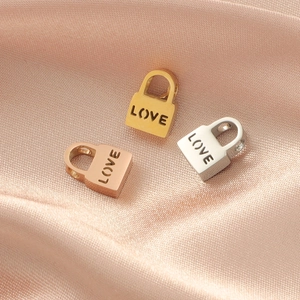 Polished LOVE lock beads in gold, rose gold, and silver finishes on pink silk