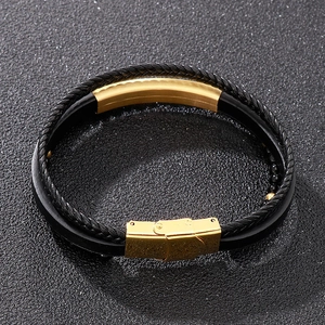 Macro shot of black woven leather layers and polished gold stainless steel buckle on bracelet