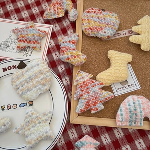 Detailed view of festive knitted Christmas ornaments including stars and tiny trees