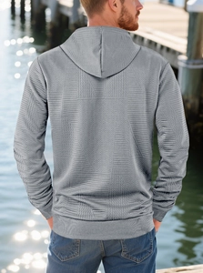Detail of grey men's hoodie showing premium geometric jacquard texture and drawstring hood