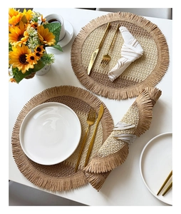 Detail of woven placemat with fringed edges featuring golden cutlery and sunflowers