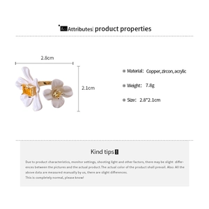 Detailed view of gold plated flower open ring with white petals and yellow cubic zirconia