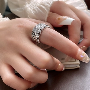 Détail d'une bague fleur ajourée en argent avec zircons sur la main du mannequin