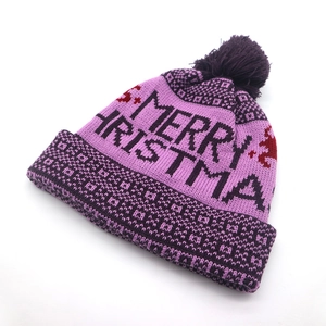 Detailed view of purple knit Christmas hat with soft pompom and Merry Christmas text