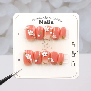 Detailed macro view of handmade short press-on nails with white flowers and pearls