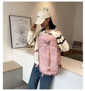 Detail view of pink multi-compartment travel backpack worn on model for casual styling