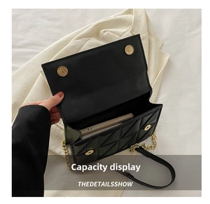 Close-up of black quilted crossbody bag showing interior capacity and magnetic buckles