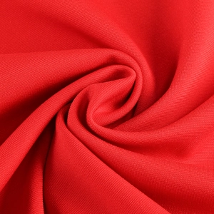 Macro shot of red knit fabric texture showing elegant draping and smooth pleated ripples