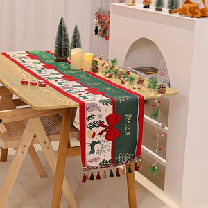 Detailed view of Christmas table runner with festive deer prints and decorative tassels