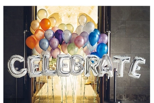Silver foil balloons spelling CELEBRATE with colorful latex balloons at a grand party entrance