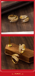 Detail of gold wheat ear rings with marquise-cut zircons on a wooden display stand