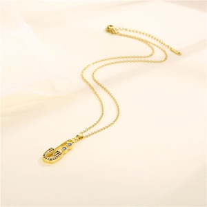 Golden safety pin necklace with colorful zircon and blue evil eye charm on an O-chain