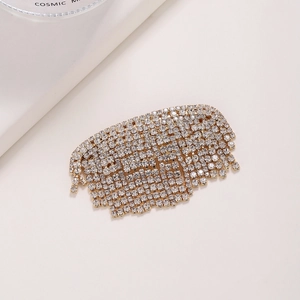 Détail d'une pince à cheveux en strass étincelants avec franges et base en métal doré