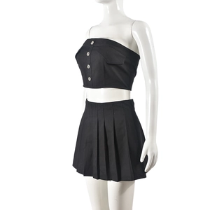 Detail view of black two-piece set featuring a tube top and pleated mini skirt with cargo pocket