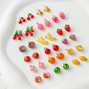 Close-up of assorted mini enamel fruit charms in gold plating for jewelry making