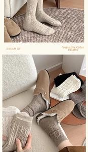 Close-up of cable knit cashmere socks paired with warm sheepskin lined mule slippers