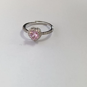 Macro shot of silver adjustable ring with pink heart zircon and surrounding crystals