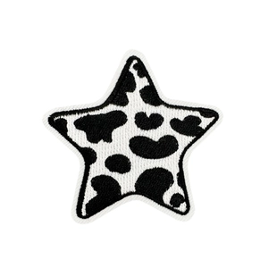 Star-shaped embroidered patch with black and white cow print texture for clothing