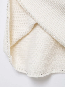 Gros plan sur la maille blanche ornée de perles élégantes et de détails en perles d'argent