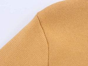 Macro detail of high-quality stitching on the shoulder of this camel knit cardigan
