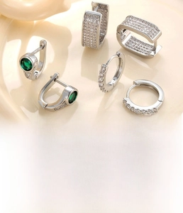 Detailed view of silver hoop earrings set with zircon, featuring horseshoe and round designs