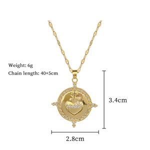 Detail of gold circular pendant with cross and heart motifs, dimensions 3.4x2.8cm