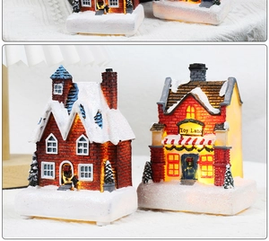 Detail of Toy Land Christmas miniature house with warm LED lighting and snow-covered resin base