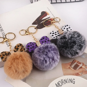 Detail of 8cm faux rabbit fur pompom keychains with leopard print and polka dot bows
