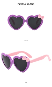 Detailed view of heart-shaped kids' sunglasses in purple and pink with a cute bow accent