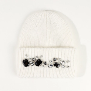 Detail of off-white knit beanie featuring black and clear rhinestone embellishments