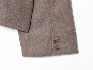 Detailed close-up of dark marble buttons and wool texture on a coffee-colored sleeve