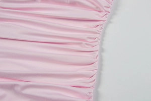 Détail de tissu satiné rose avec coutures froncées horizontales pour robe moulante