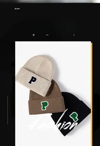 Detailed view of knitted hats in beige, brown and black with P-letter patch applique