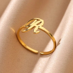 Detailed macro view of an adjustable gold-plated ring featuring the elegant cursive letter R
