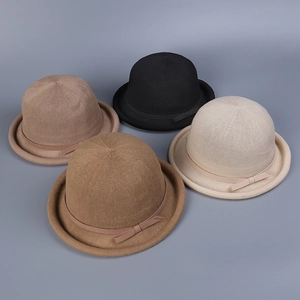 Top view of four knit bowler hats in black, beige, and brown with matching ribbon bows