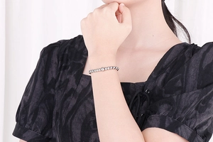 Close-up of a high-polish silver metal beaded bracelet worn on a female wrist