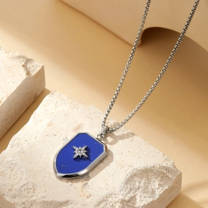 Macro detail of silver pendant with blue stone and star inlay on natural stone