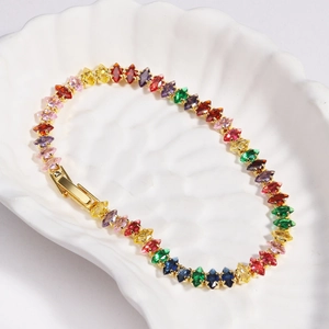 Macro shot of colorful marquise-cut zircons set on a gold-plated knotted tennis bracelet