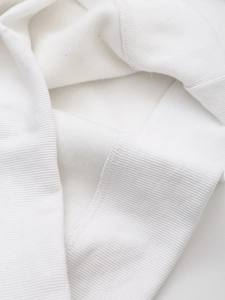 Close-up of white sweatshirt showing high-density ribbed cuffs and soft fleece lining texture