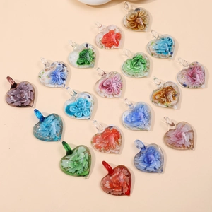 Close-up of heart-shaped glass flower pendants in various colors for jewelry making