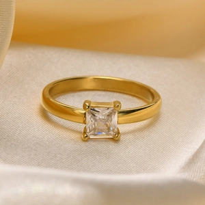 Detailed close-up of a square transparent gemstone in a gold four-prong setting