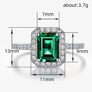 Classic silver-toned ring featuring an emerald-cut green stone with clear halo accents