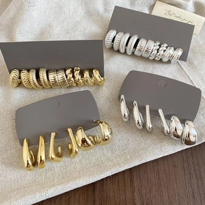Macro view of gold and silver irregular geometric hoop earrings on display card