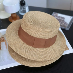 Minimalistischer Damen-Strohhut als flacher Boater mit braunem Band und Naturgeflecht