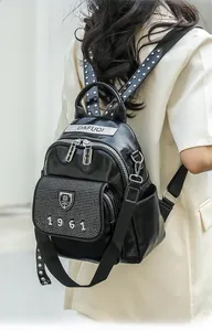 Detailed view of the sparkling rhinestone front pocket and silver studs on black backpack