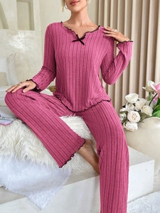 Detailed texture of ribbed knit loungewear set featuring contrast black lettuce trim