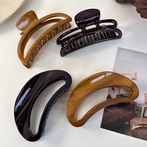Detail view of large tortoiseshell acrylic hair claws in crescent and cutout designs